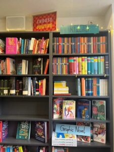 Ein Bücherregal voller bunter Bücher mit dem Schild Klassiker und verschiedenen Graphic Novels