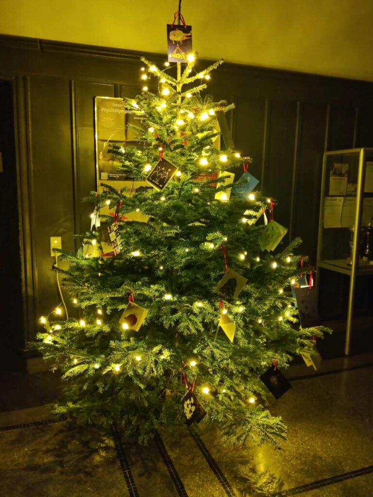 Ein festlich beleuchteter Weihnachtsbaum mit vielen Karten und warmen Lichtern