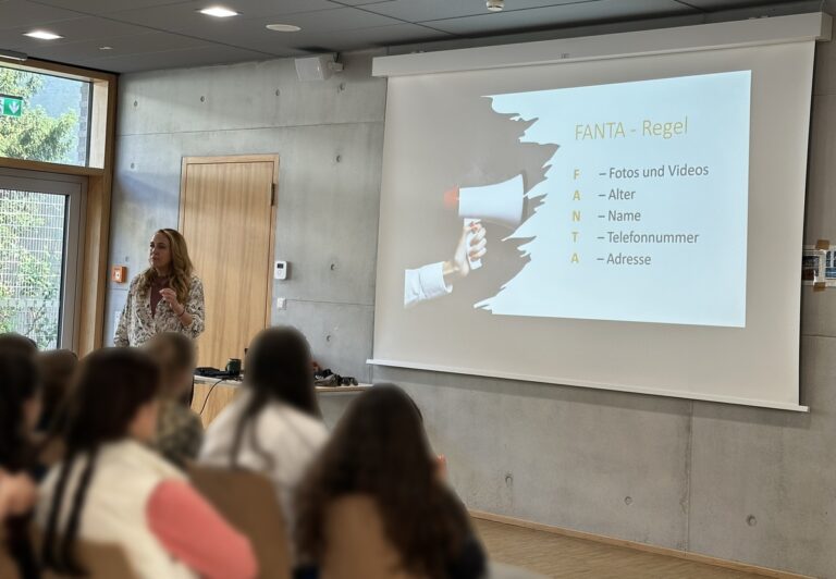 Referentin mit ruhigem Blick vor Folie, grauer Raum, FANTA Regel