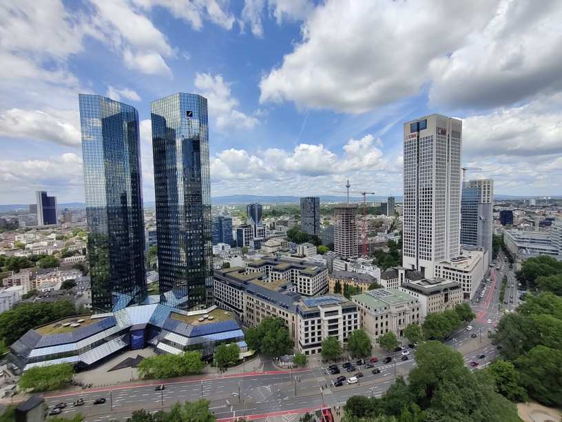 Frankfurt Skyline mit modernen Hochhäusern, Glasfassaden und grünen Bäumen
